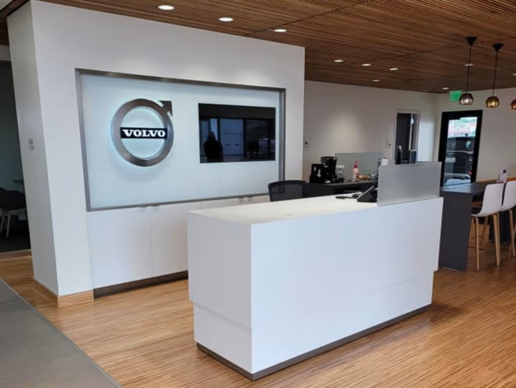Interior reception area of the Volvo dealership with a white desk