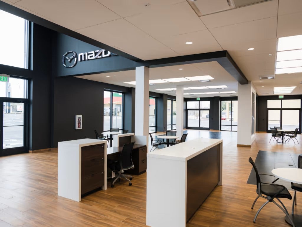 A reception-style workspace with seating and a Mazda logo sign