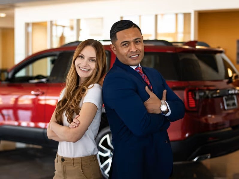 Two people standing back-to-back inside the dealership showroom