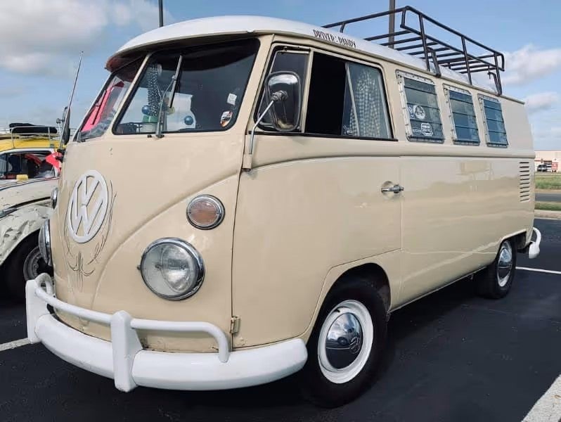 A cream-colored classic Volkswagen van parked outdoors