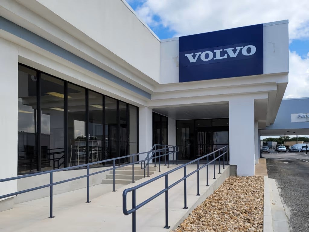 Exterior view of a Volvo dealership building with a blue “Volvo” sign